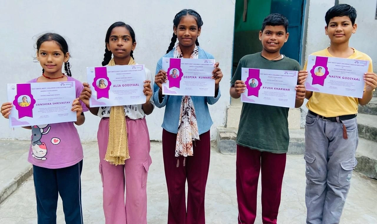 Five EMWCEF scholarship recipients proudly holding their certificates — Rishikesh, India 2025